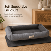 Gray pet bed with text highlighting its soft supportive enclosure feature, placed on a wooden floor.
